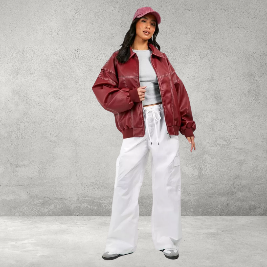 Model wearing red faux leather bomber jacket, walking pose