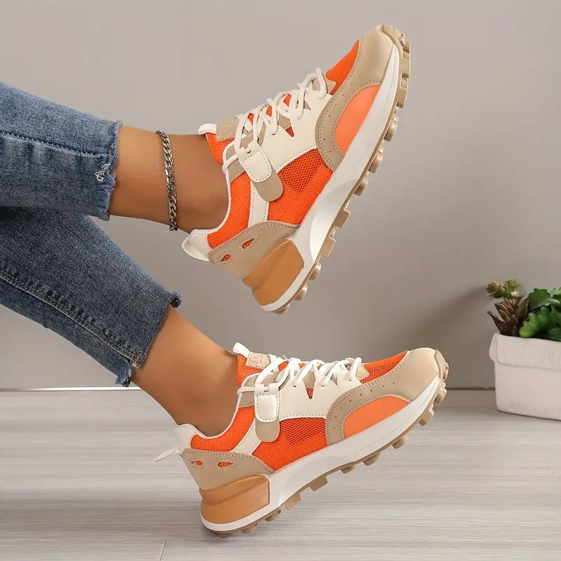 Model wearing white and orange sneakers, walking pose
