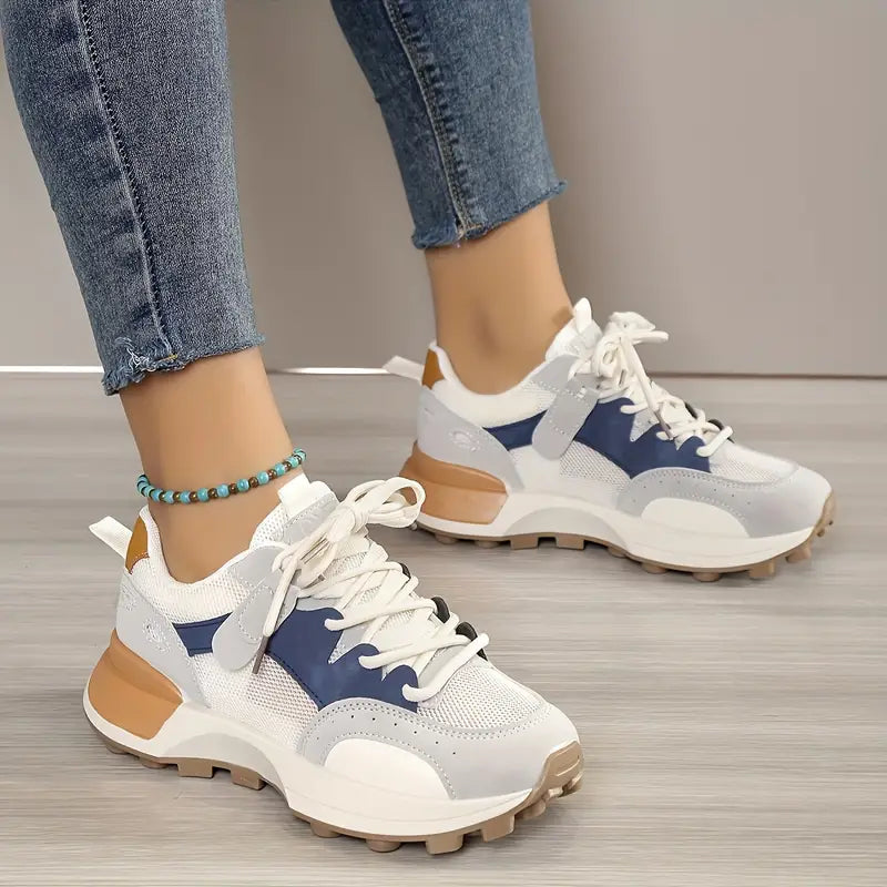 Model wearing sneakers with denim jeans, front view