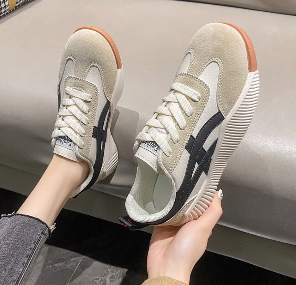 Model holding Black and beige sneakers