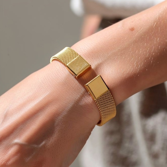 Woman wearing gold-tone mesh cuff bracelet with open design on her wrist