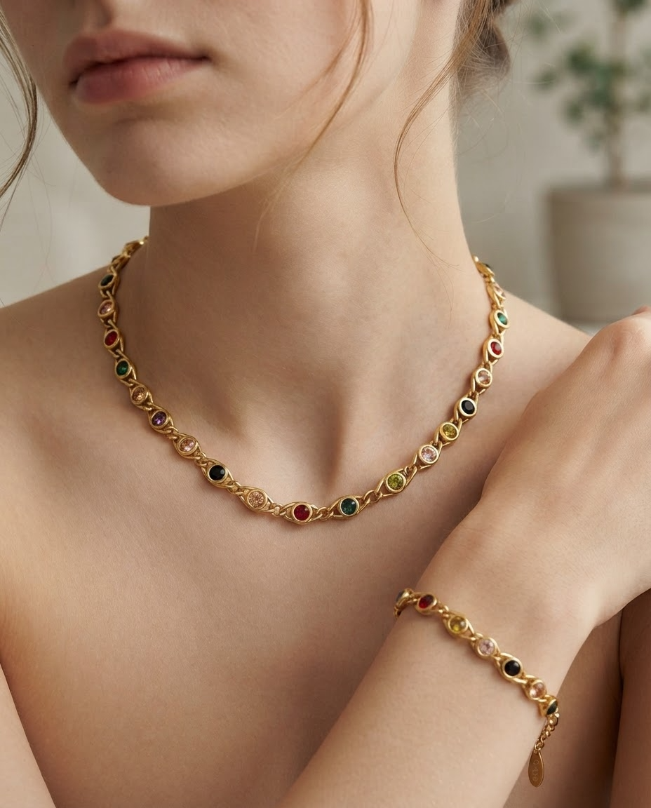 Woman wearing matching jewelry set featuring gold-tone necklace and bracelet with multicolored round gemstones