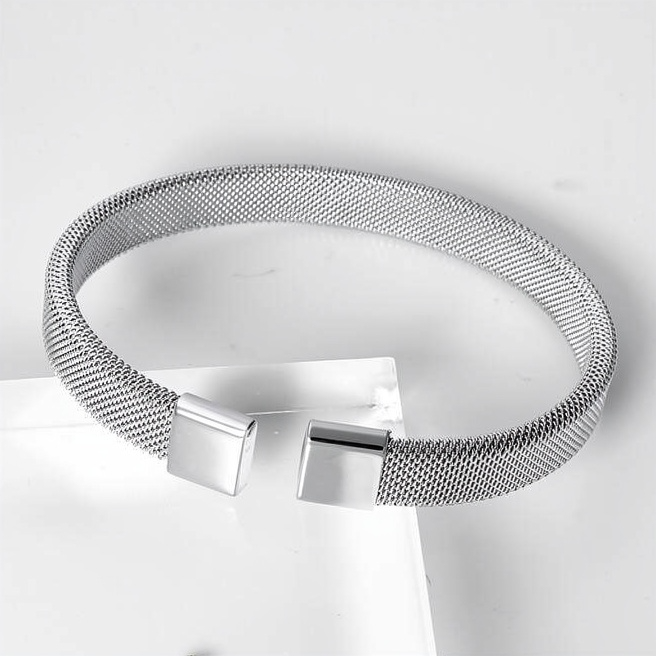 Silver-tone mesh bracelet with open cuff design and square terminals on white studio background