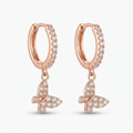 Rose gold-toned huggie hoop earrings with pavé crystal stones and dangling butterfly charm - elegant small hinged hoop earrings with crystal butterfly pendant - jewelry product photo