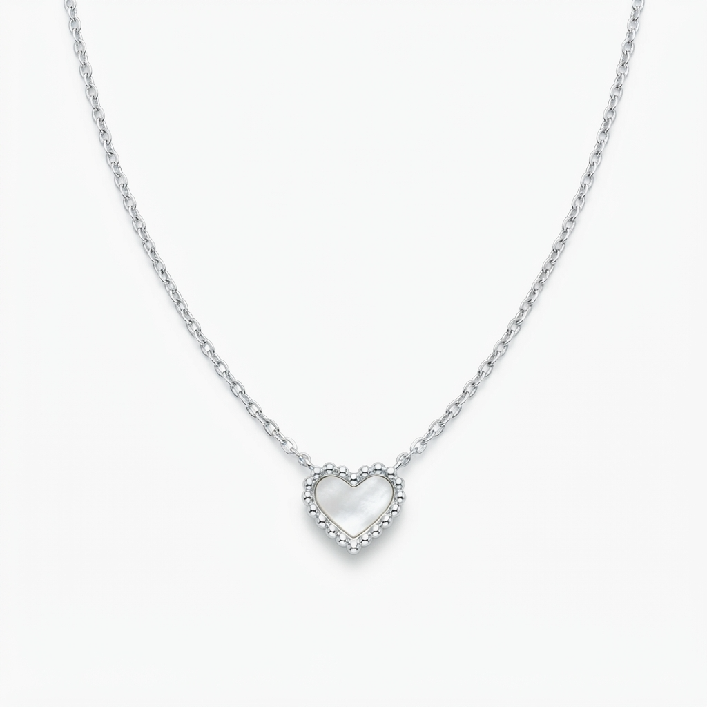 Silver-toned necklace with mother-of-pearl heart pendant detail – luxury chain necklace with shimmering pearlescent heart charm and scalloped silver frame – close-up product photography