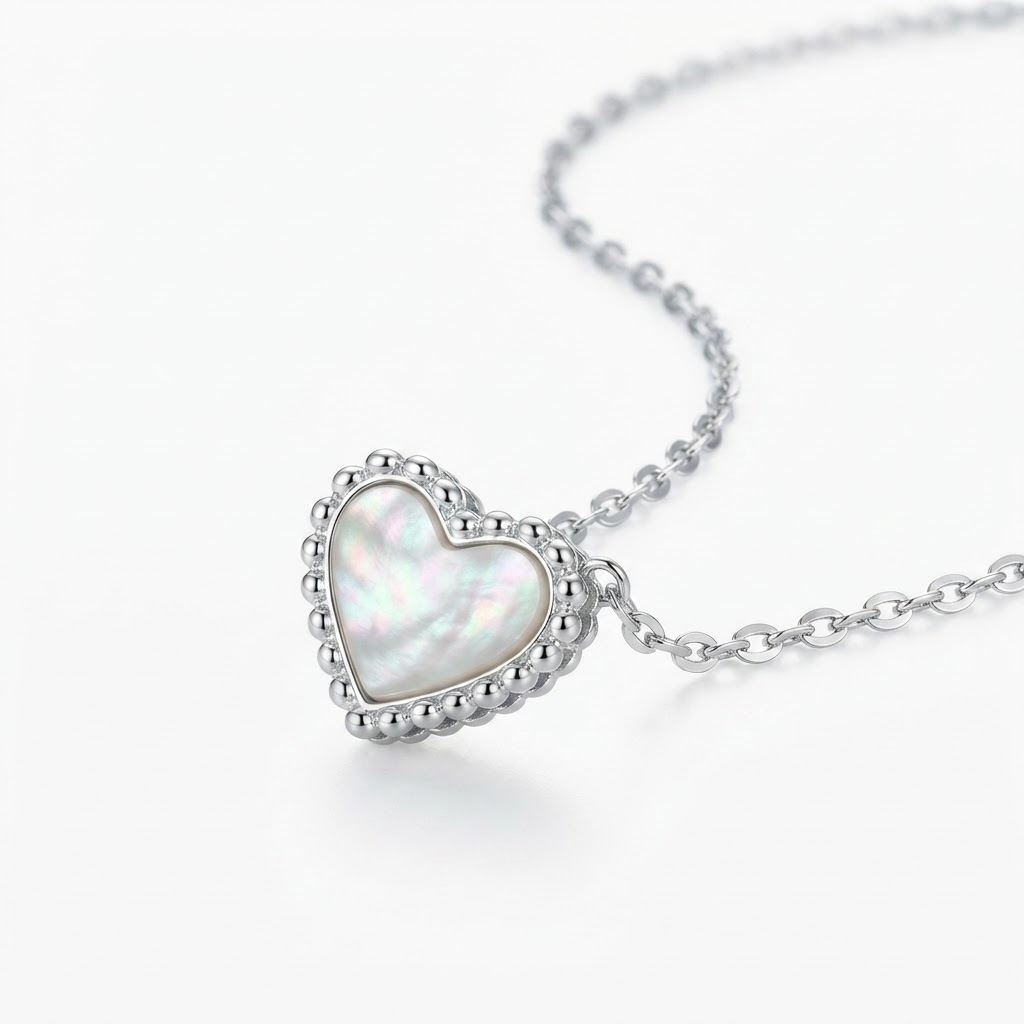 Silver-toned delicate chain necklace with iridescent mother-of-pearl heart pendant – elegant adjustable necklace with pearlescent heart charm and beaded silver border – jewelry product photo