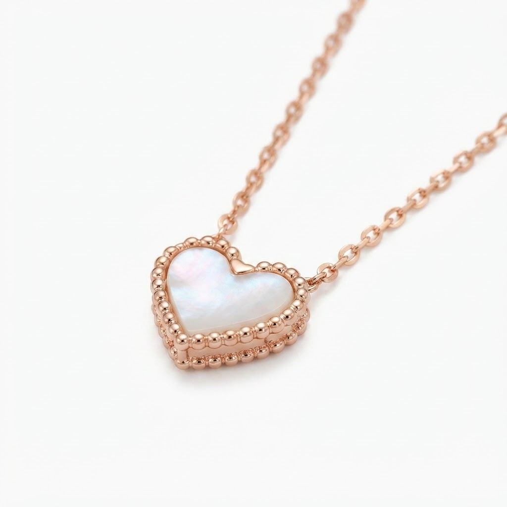 Rose gold-toned delicate chain necklace with iridescent mother-of-pearl heart pendant – elegant adjustable necklace with pearlescent heart charm and beaded rose gold border – jewelry product photo