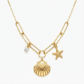 Gold-toned hybrid chain necklace with marine-themed charms – elegant mixed-chain necklace featuring asymmetrically placed scallop shell, starfish, and crystal cubic zirconia pendants in V-shape design – jewelry product photo