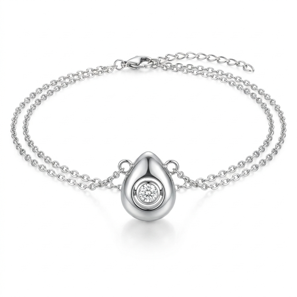 Silver-toned puffy teardrop pendant with rotating crystal detail – three-dimensional organic droplet with movable bezel-set crystal in circular concave setting – extreme macro close-up product photograph