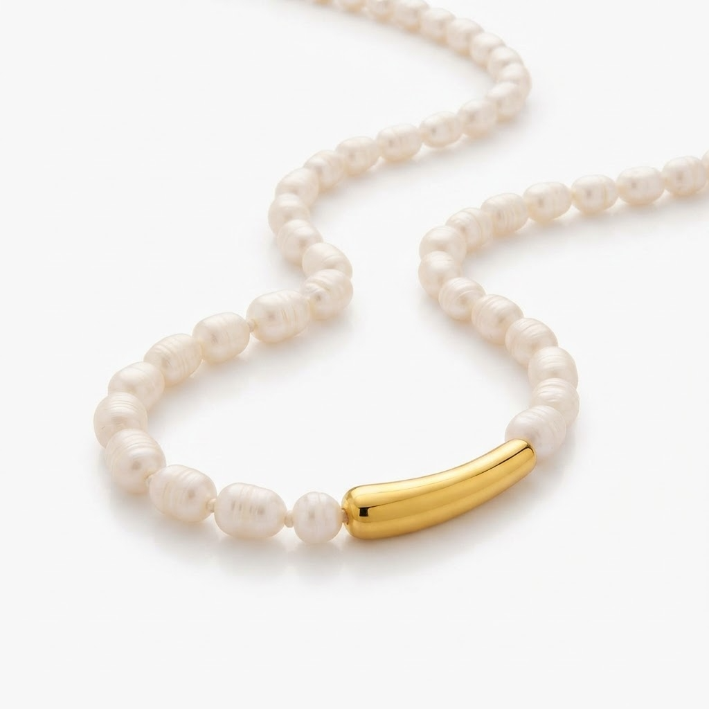 Faux pearl necklace with gold-toned tube detail - luxury pearl beaded necklace with curved gold-tone bar - close-up product photography
