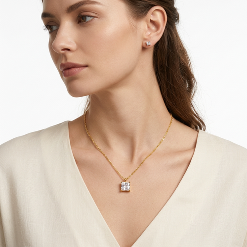 Vrouw draagt goudkleurige ketting met princess-cut kristal hanger - elegante halsketting styling foto - luxe sieraden lifestyle fotografie