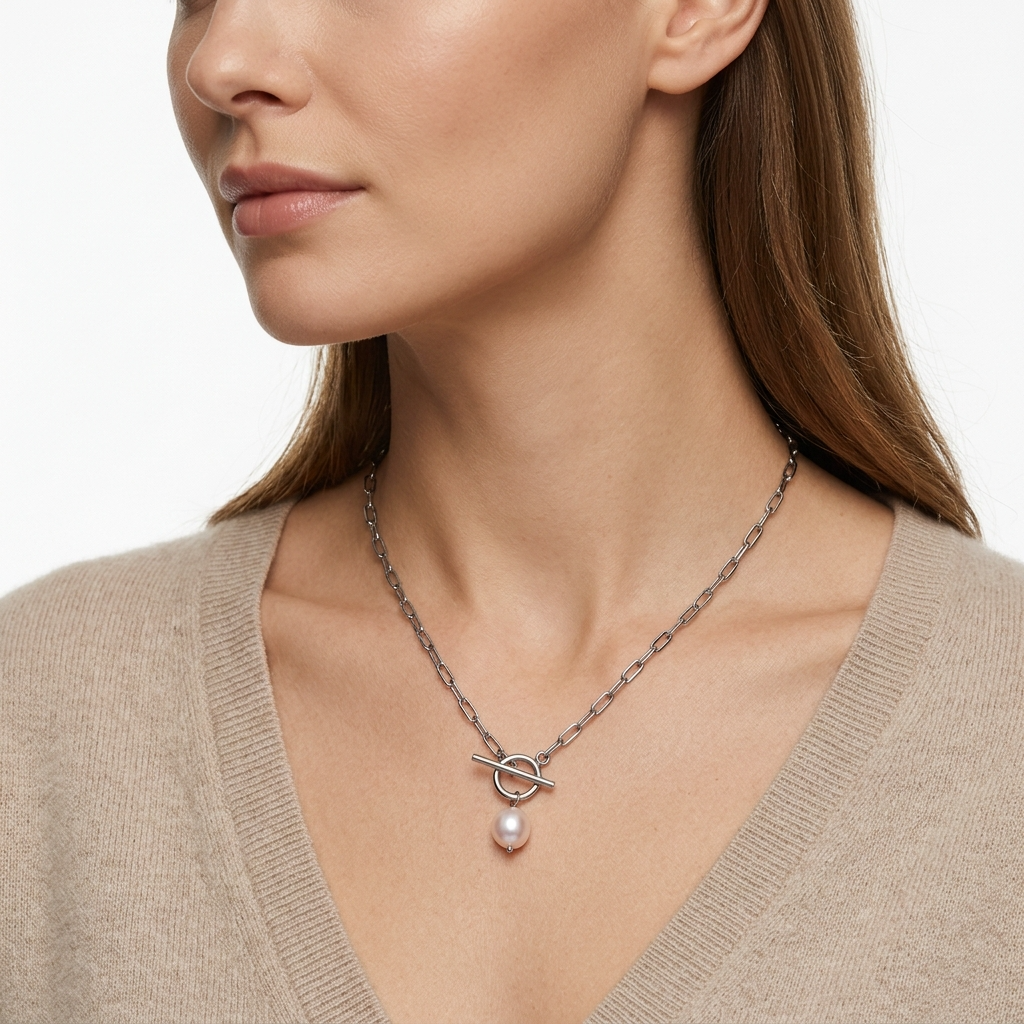 Woman wearing silver-toned paperclip chain necklace with toggle clasp and faux pearl pendant - elegant necklace styling photo - luxury jewelry lifestyle photography