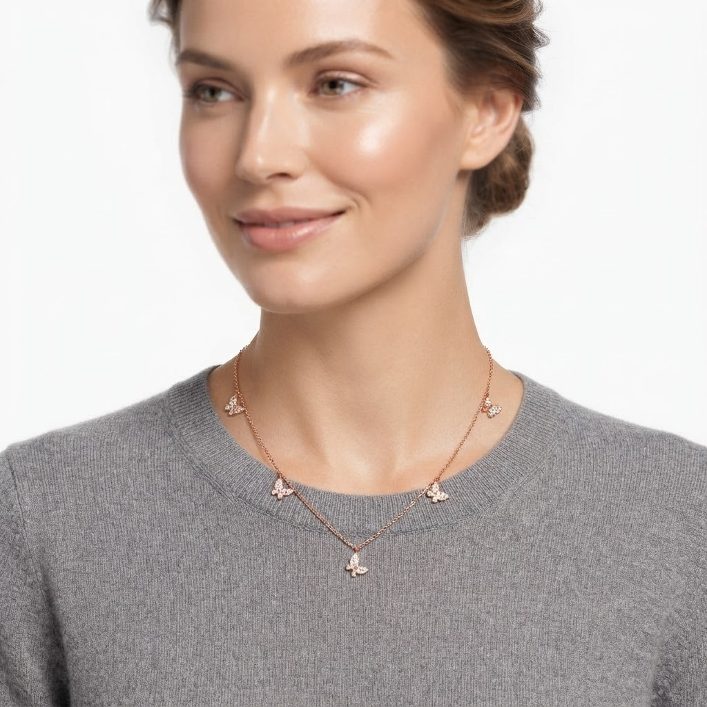 Woman wearing rose gold-toned chain necklace with crystal butterfly charms - elegant butterfly station necklace styling photo - luxury jewelry lifestyle photography
