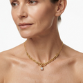 Woman wearing gold-toned delicate necklace with double oval chain links and square crystal pendant - elegant layered chain necklace styling photo - luxury jewelry lifestyle photography