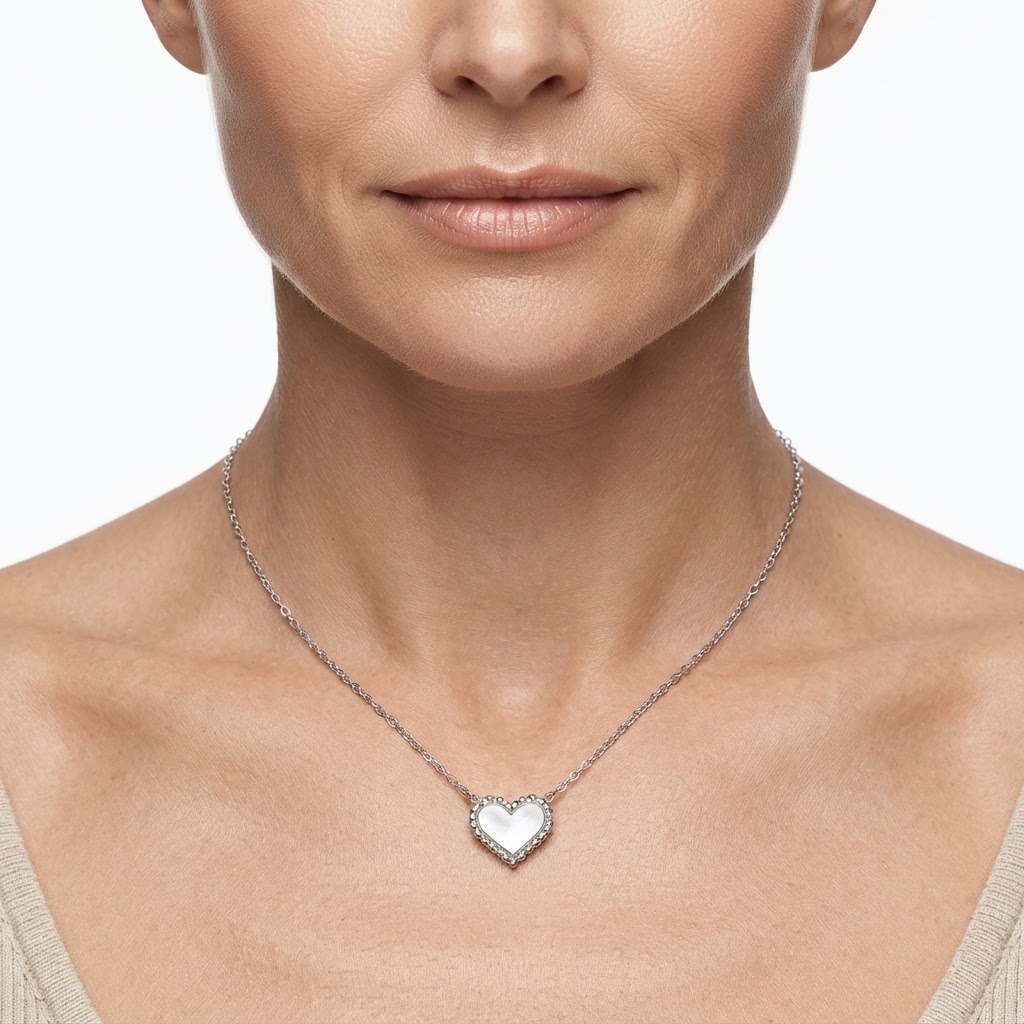 Woman wearing silver-toned delicate chain necklace with iridescent mother-of-pearl heart pendant – elegant pearlescent heart necklace styling photo – luxury jewelry lifestyle photography
