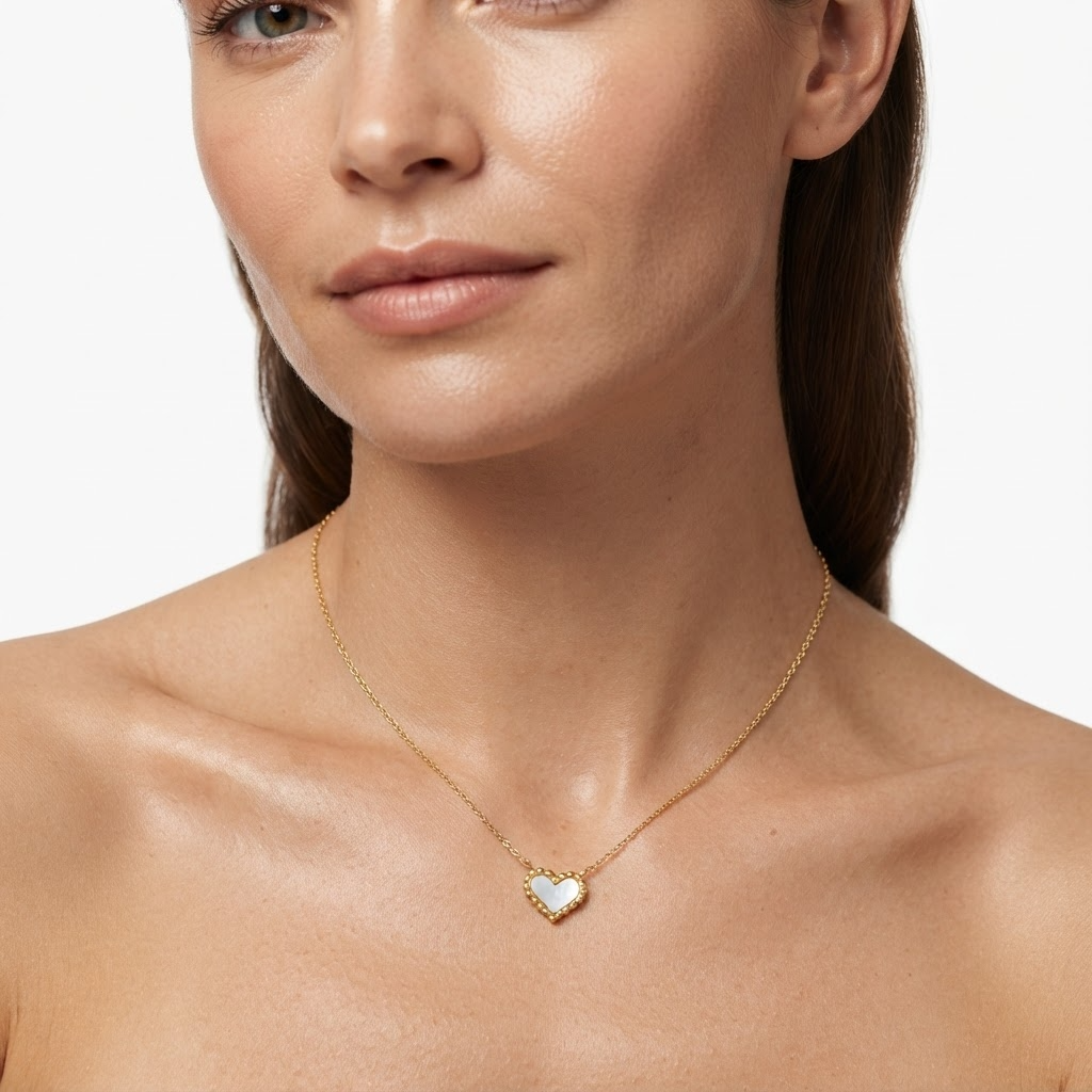 Woman wearing gold-toned delicate chain necklace with iridescent mother-of-pearl heart pendant – elegant pearlescent heart necklace styling photo – luxury jewelry lifestyle photography