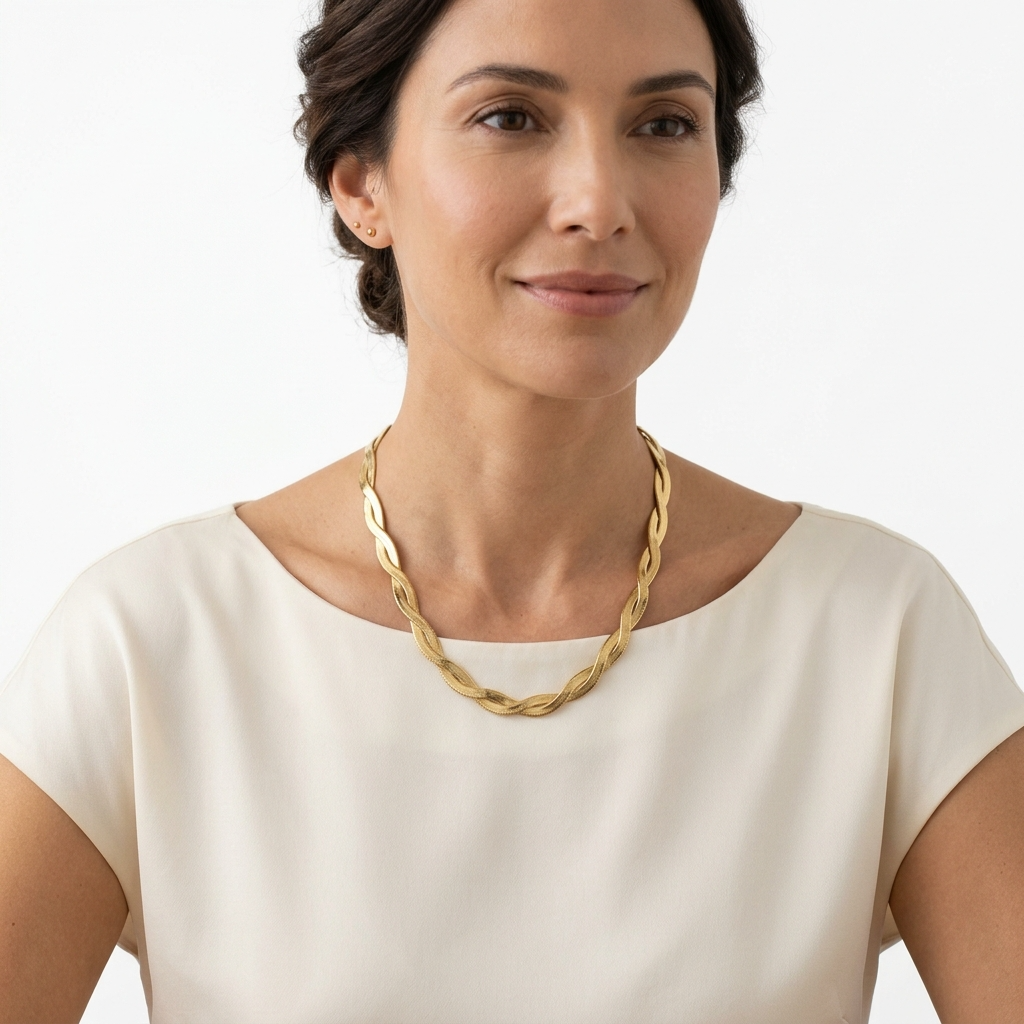 Woman wearing twisted herringbone chain necklace in gold color with black dress – Velara