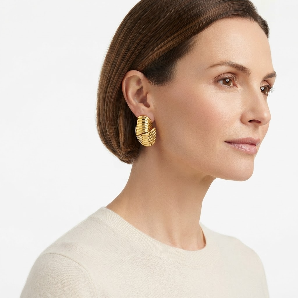 Woman wearing gold-toned chunky ribbed C-hoop earrings - bold textured hoop earrings styling photo - luxury jewelry lifestyle photography