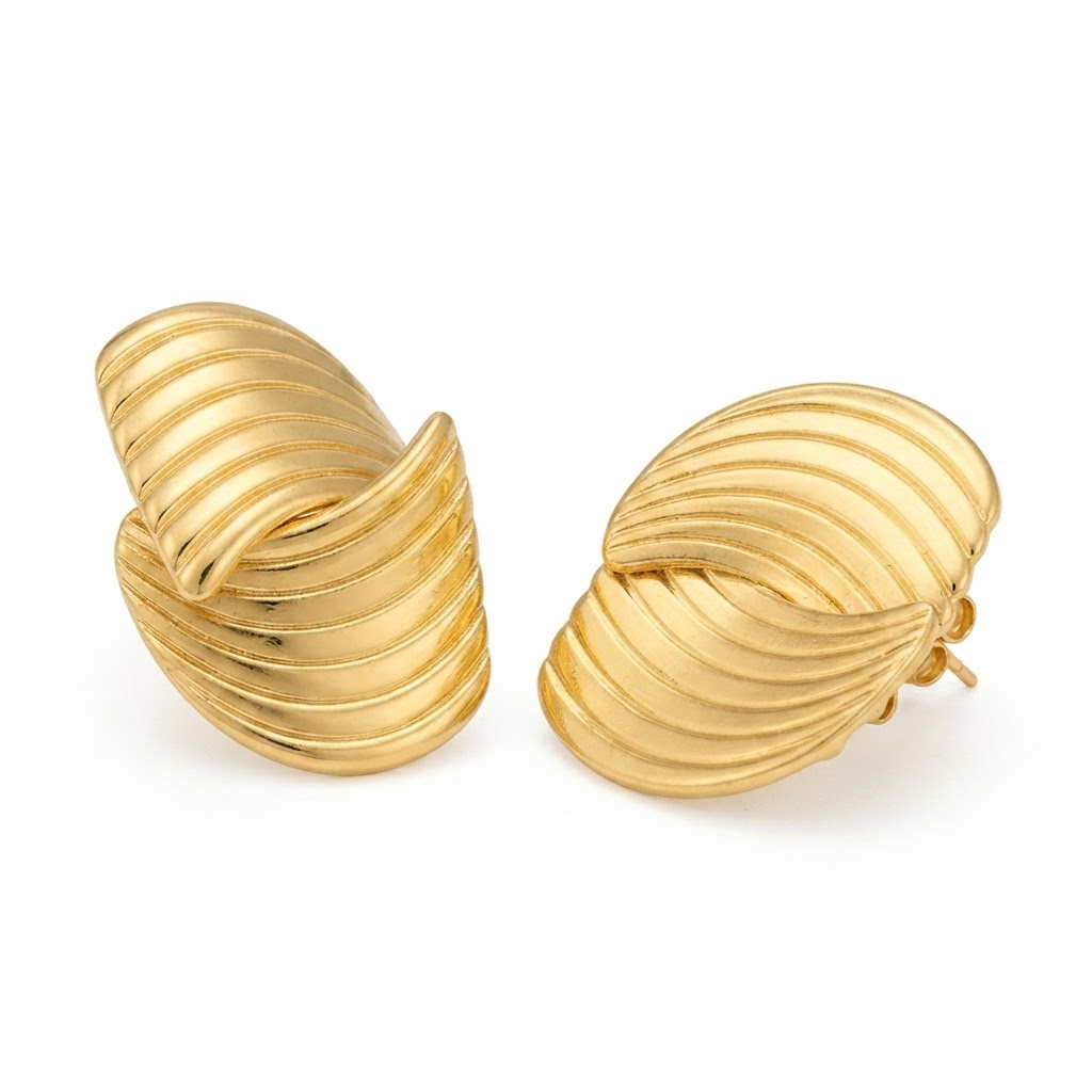 Gold-toned ribbed C-hoop earrings detail - luxury sculptural hoop earrings with dimensional ribbed texture - close-up product photography