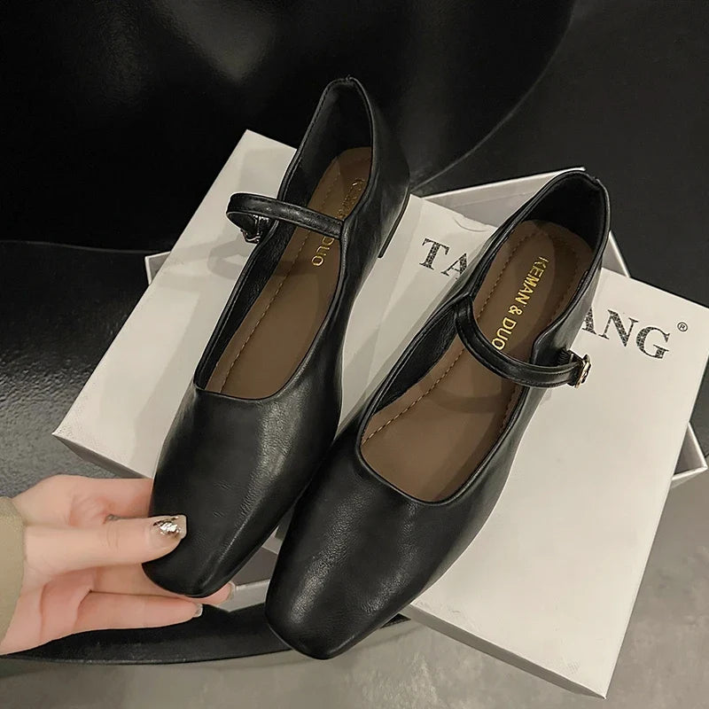 Model holding brown low heel mule