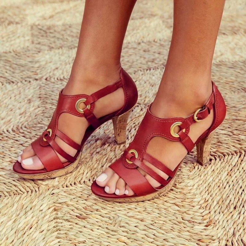 Model wearing red strappy heeled sandals on sand