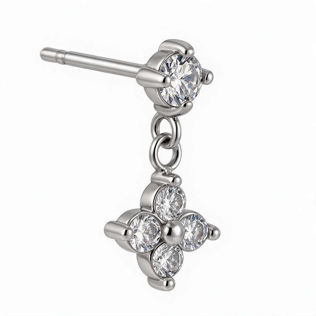 Macro close-up of silver-tone flower-shaped CZ dangle earring with prong settings