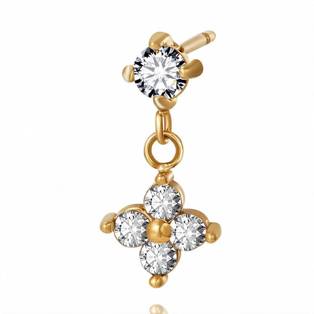Macro close-up of gold-tone flower CZ dangle earring with four prong settings and center bead