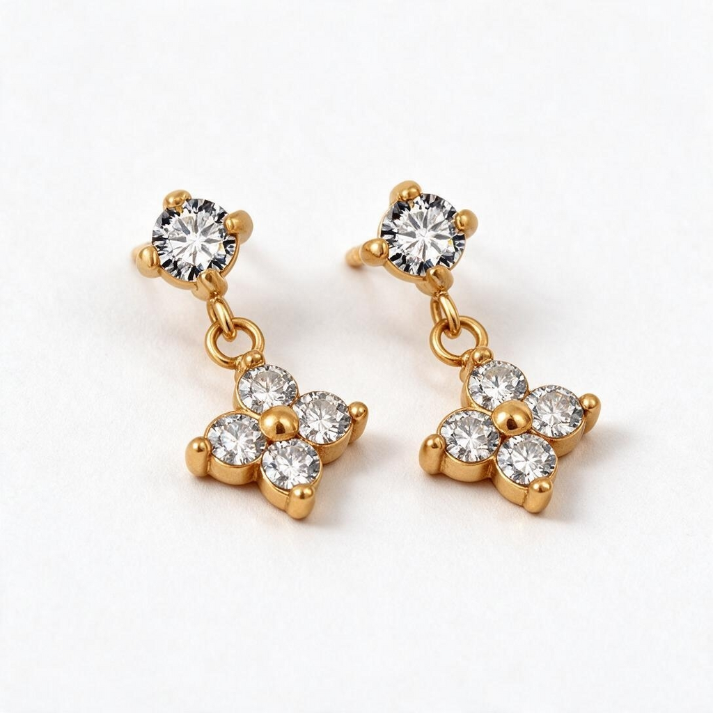 Gold-tone stud earrings with four-petal flower dangle set with small clear crystals around a center bead, studio pair on white