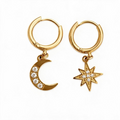 Gold-tone hinged hoop earrings with dangling moon and star charms set with clear crystals, studio white background