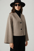 Taupe cropped jacket studio detail showing black buttons, welt pockets and brushed wool texture close up - Velara UK