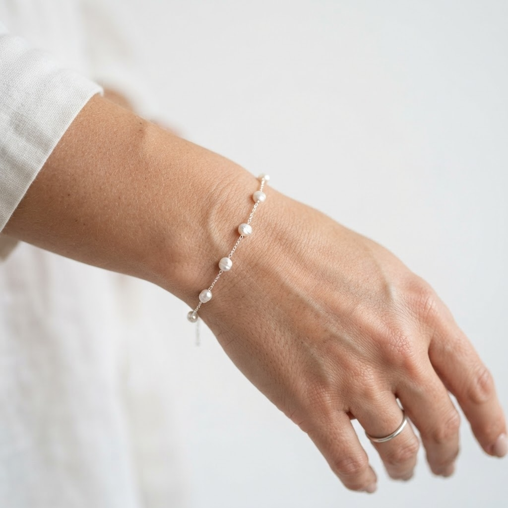 Woman wearing silver-toned stainless steel chain bracelet with five baroque pearls – elegant minimalist pearl bracelet styling photo – luxury jewelry lifestyle photography