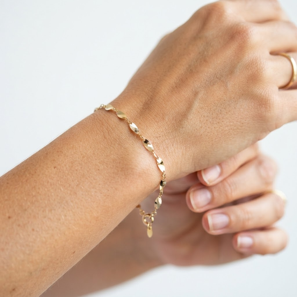 Woman wearing gold-toned delicate wave link bracelet – elegant minimalist reflective mirror link bracelet styling photo – luxury jewelry lifestyle photography