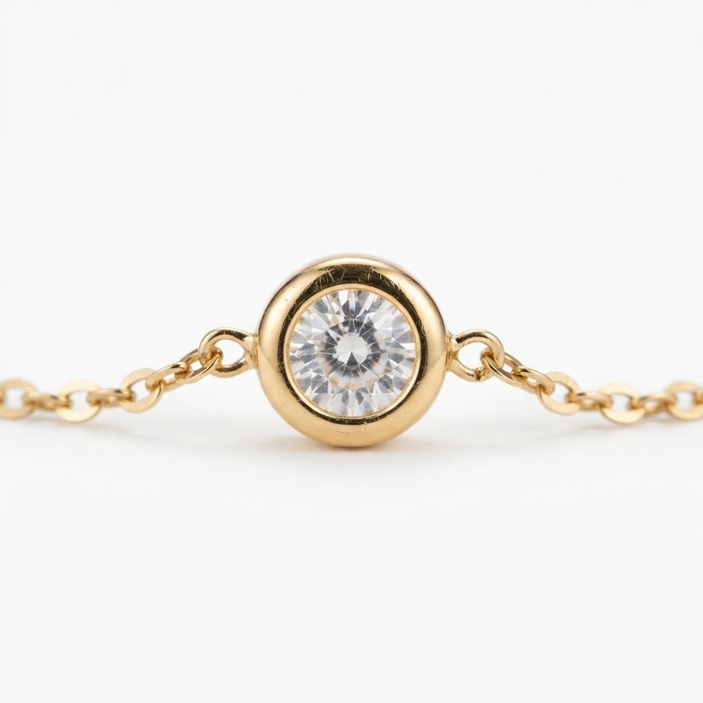 Gold-toned bezel crystal bracelet detail – single round bezel-set cubic zirconia on thin cable chain – extreme close-up product photography