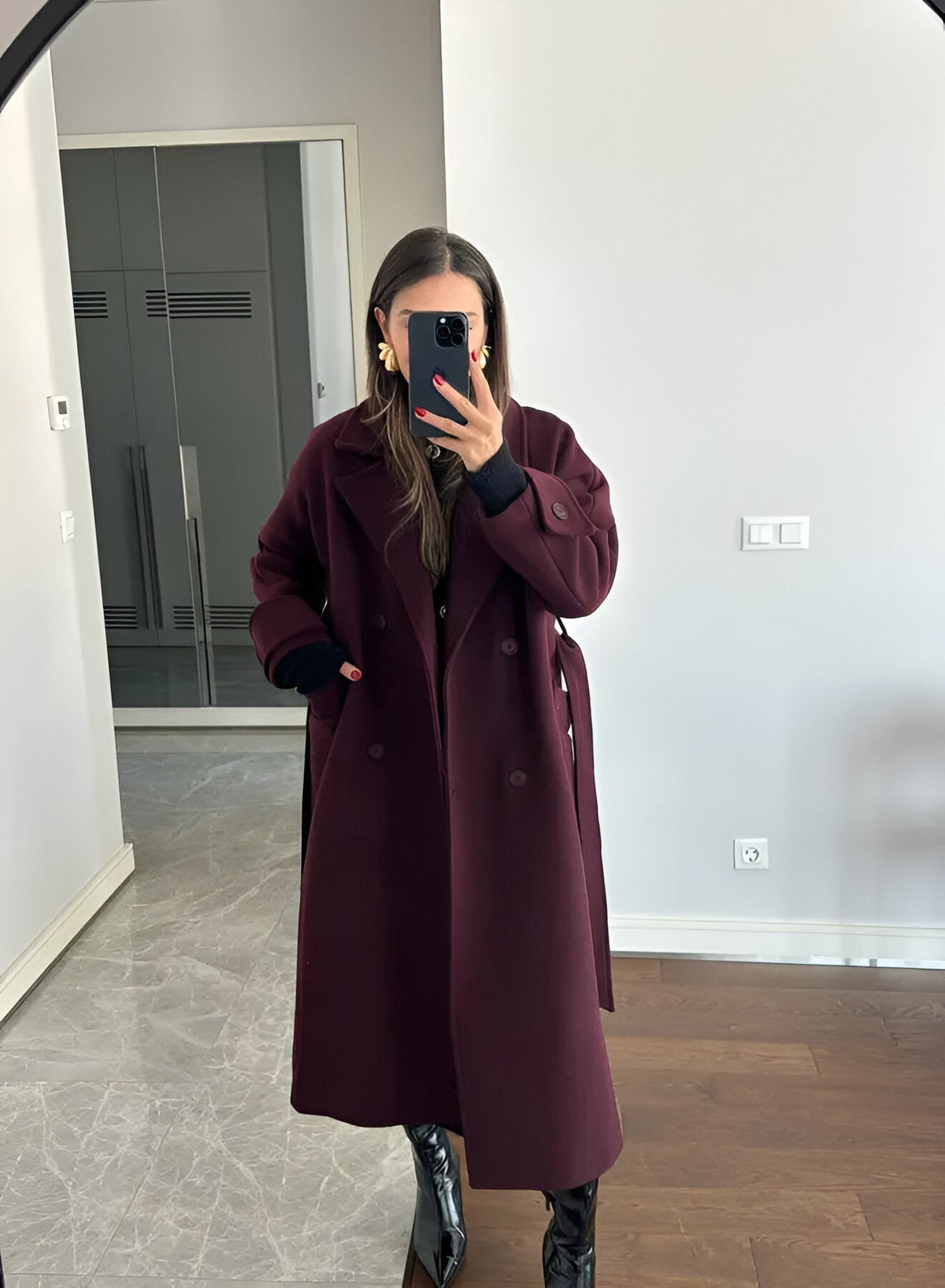 Model wearing burgundy coat outdoors