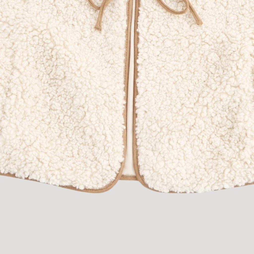 Model wearing beige tie-front vest with dress