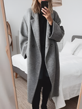 Woman wearing a long loose-fit button-front coat, front view