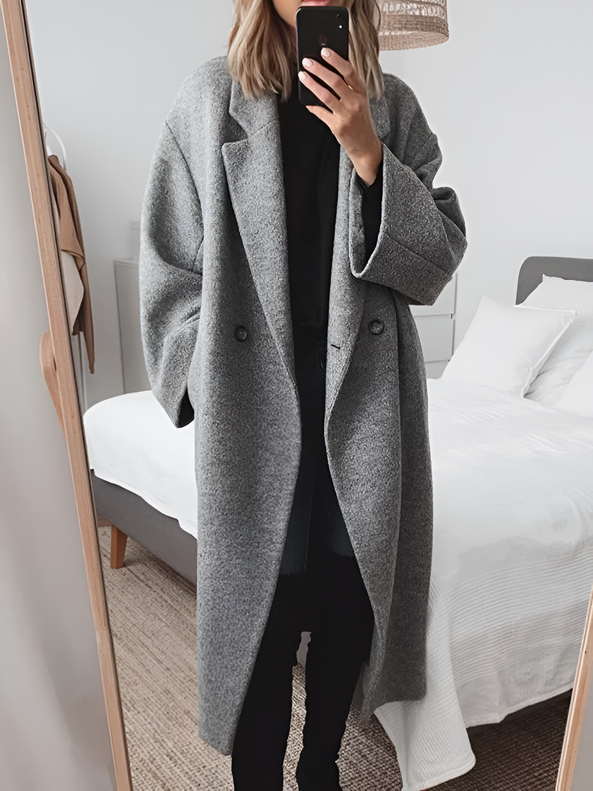 Woman wearing a long loose-fit button-front coat, front view