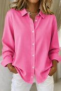 Woman wearing loose fit button-down blouse front view